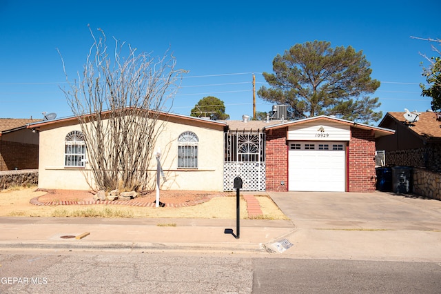 ranch-style home with a garage and central air condition unit