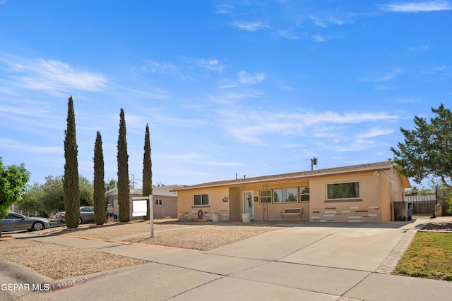 single story home with concrete driveway and stucco siding