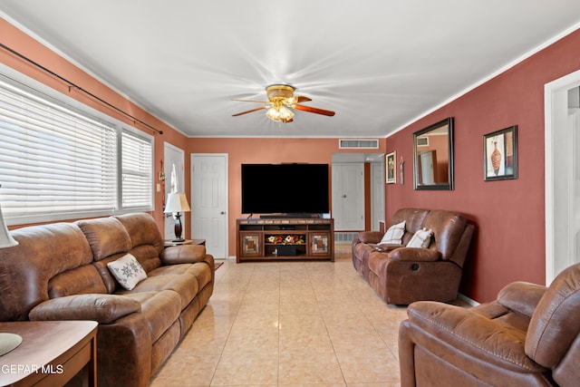 living area with light tile patterned floors, ceiling fan, visible vents, and crown molding