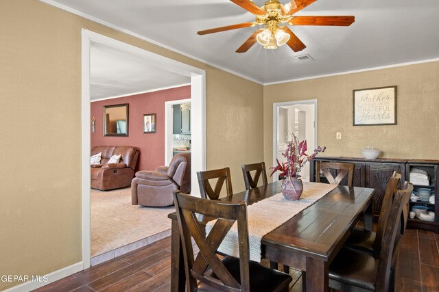 dining space featuring dark wood-type flooring, crown molding, and ceiling fan