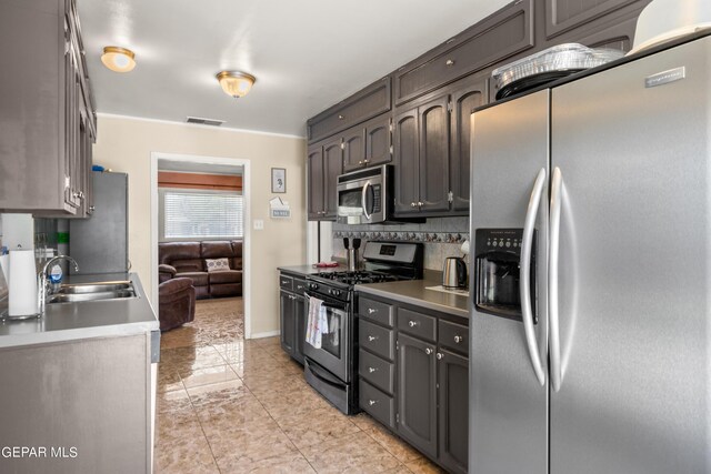 kitchen featuring sink, tasteful backsplash, stainless steel appliances, and light tile patterned floors