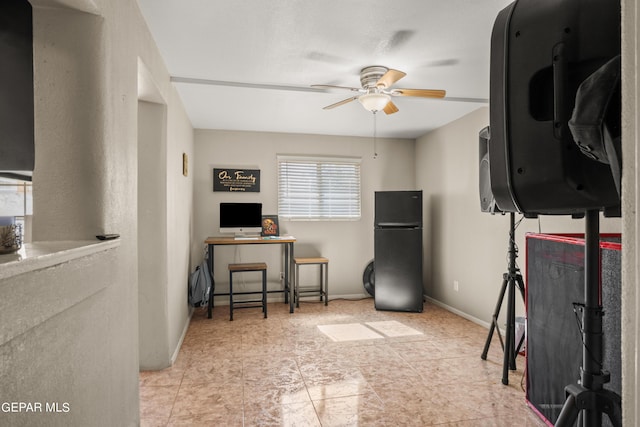 office space featuring a ceiling fan and baseboards