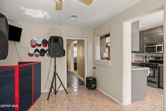 workout room featuring a ceiling fan, visible vents, and baseboards