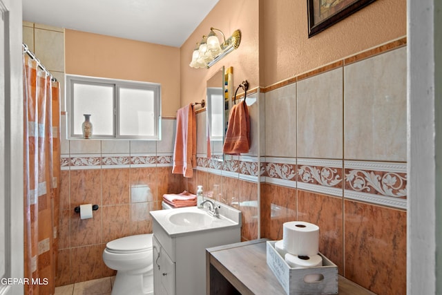 full bath with toilet, vanity, and tile walls