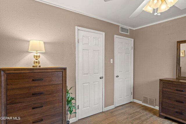 bedroom with hardwood / wood-style flooring, ornamental molding, and ceiling fan