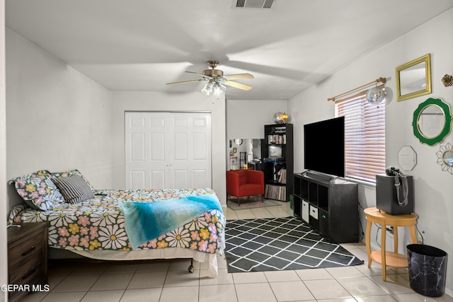 bedroom with tile patterned flooring, ceiling fan, and a closet