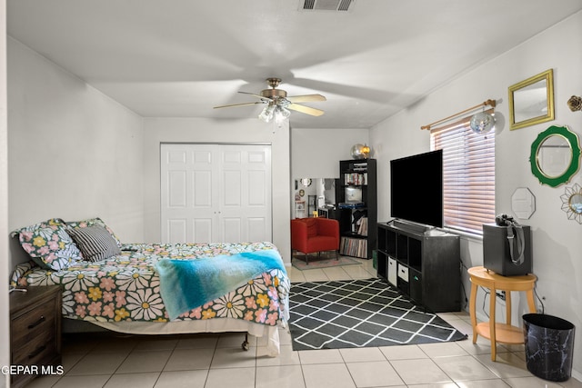 tiled bedroom with a closet, visible vents, and a ceiling fan