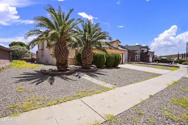 view of front of property with stucco siding, driveway, and a garage