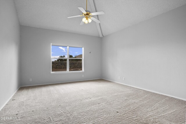 carpeted spare room featuring a textured ceiling, ceiling fan, and lofted ceiling