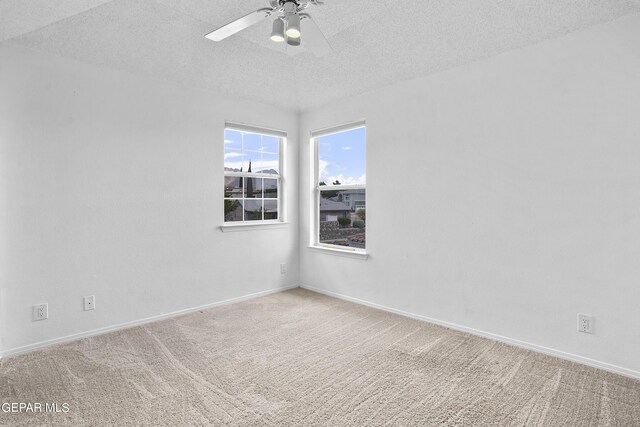 carpeted spare room featuring ceiling fan and a textured ceiling