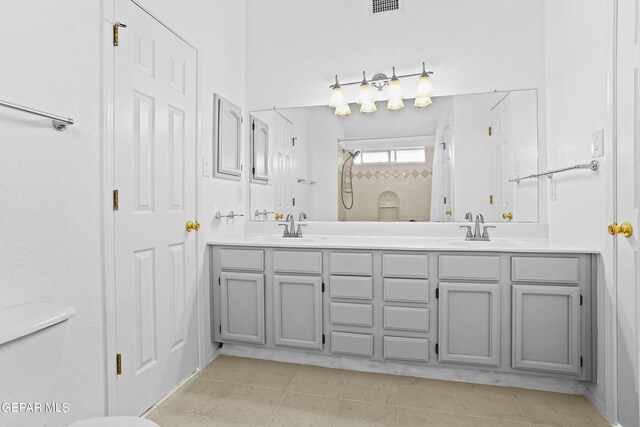 bathroom with tile patterned floors, walk in shower, and vanity