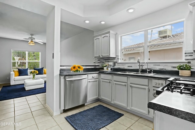 kitchen featuring dishwasher, sink, plenty of natural light, and light tile patterned flooring