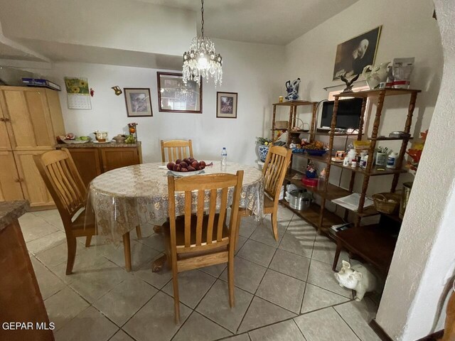 dining area with a chandelier and light tile patterned floors