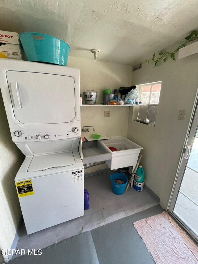 laundry room featuring stacked washer / drying machine