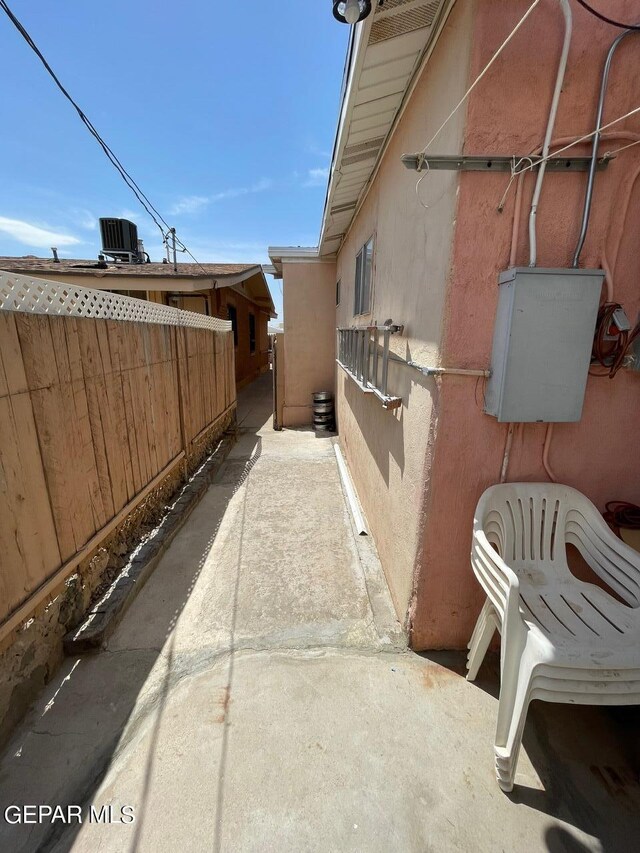 view of side of property with central air condition unit and a patio area