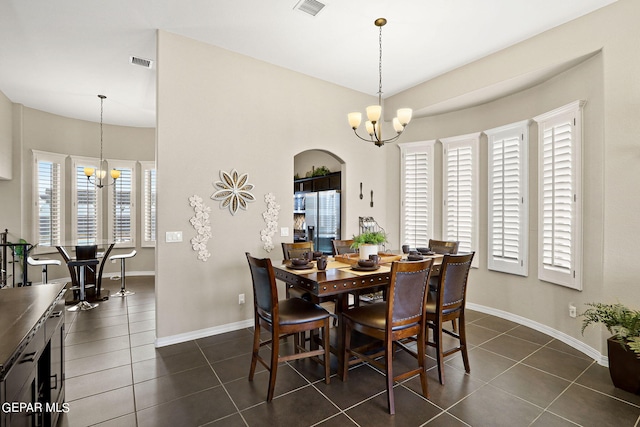 tiled dining area featuring a chandelier