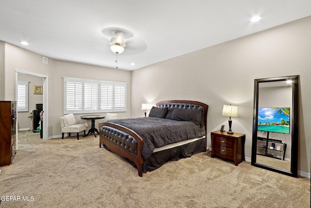 bedroom featuring ceiling fan, light carpet, and multiple windows