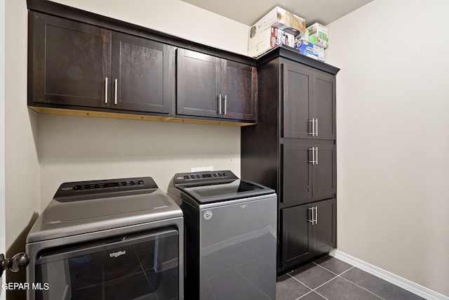 laundry room with cabinets, separate washer and dryer, and dark tile patterned flooring