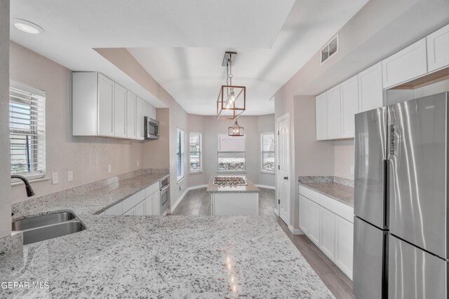 kitchen featuring sink, plenty of natural light, appliances with stainless steel finishes, and light stone countertops