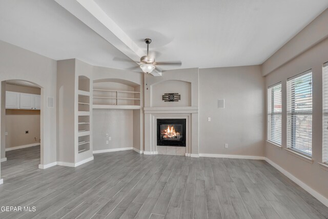 unfurnished living room with light hardwood / wood-style flooring, ceiling fan, and built in features