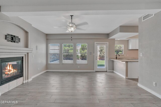 unfurnished living room with ceiling fan