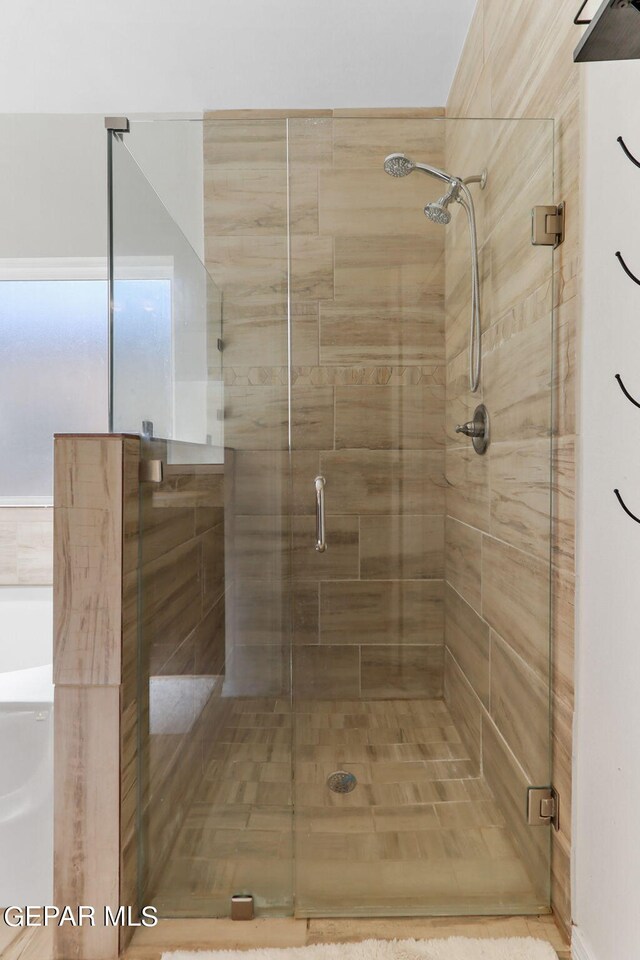 bathroom featuring a shower with door