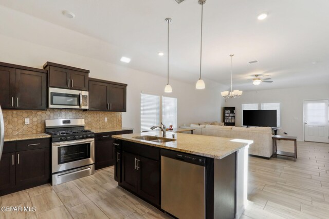 kitchen with light stone countertops, stainless steel appliances, sink, decorative backsplash, and dark brown cabinetry