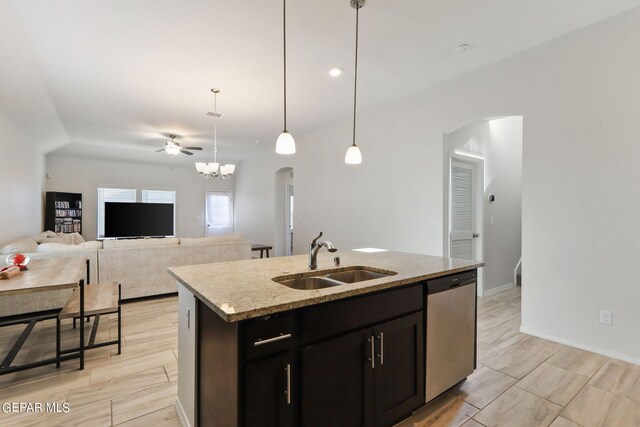 kitchen with light stone countertops, a center island with sink, pendant lighting, stainless steel dishwasher, and sink