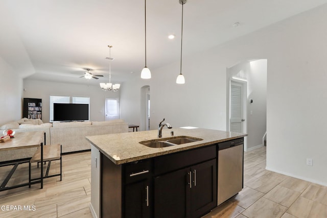 kitchen with a sink, decorative light fixtures, dishwasher, arched walkways, and a kitchen island with sink