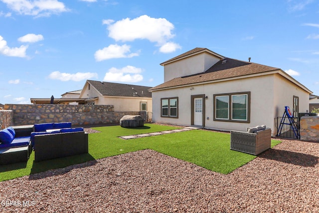 rear view of property with stucco siding, a lawn, outdoor lounge area, and fence