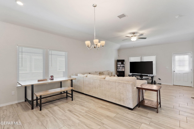 living room with visible vents, ceiling fan with notable chandelier, and baseboards