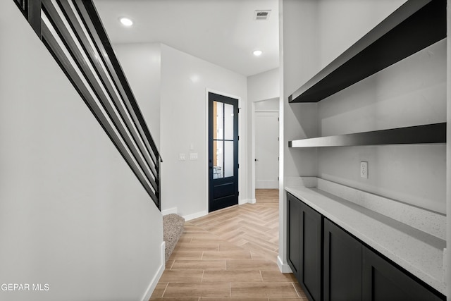 interior space with recessed lighting, visible vents, stairway, wood tiled floor, and baseboards