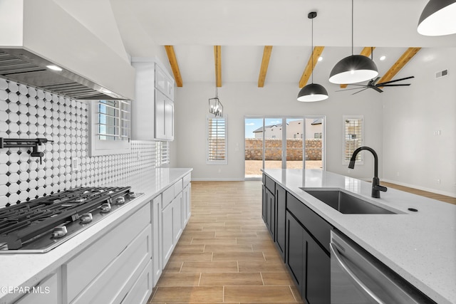 kitchen featuring visible vents, appliances with stainless steel finishes, premium range hood, white cabinetry, and a sink