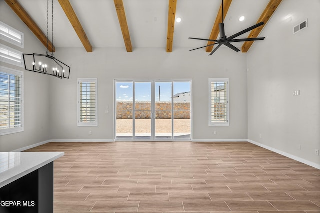 unfurnished living room with light wood-type flooring, visible vents, baseboards, and ceiling fan with notable chandelier