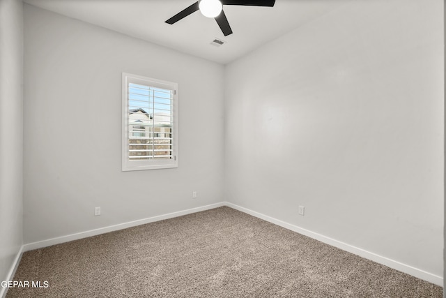 carpeted empty room with baseboards, visible vents, and ceiling fan