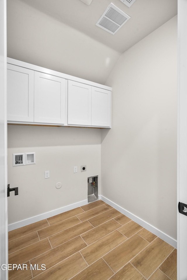 laundry room with cabinet space, visible vents, gas dryer hookup, wood finish floors, and washer hookup