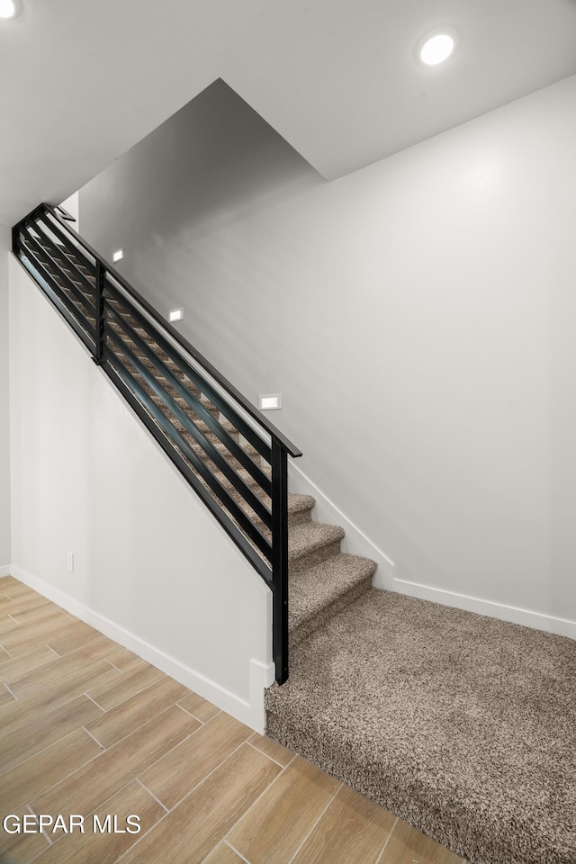 stairway with baseboards, recessed lighting, and wood tiled floor