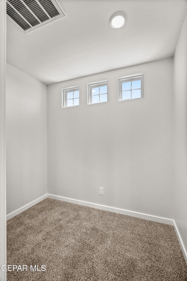 below grade area with carpet, visible vents, and baseboards