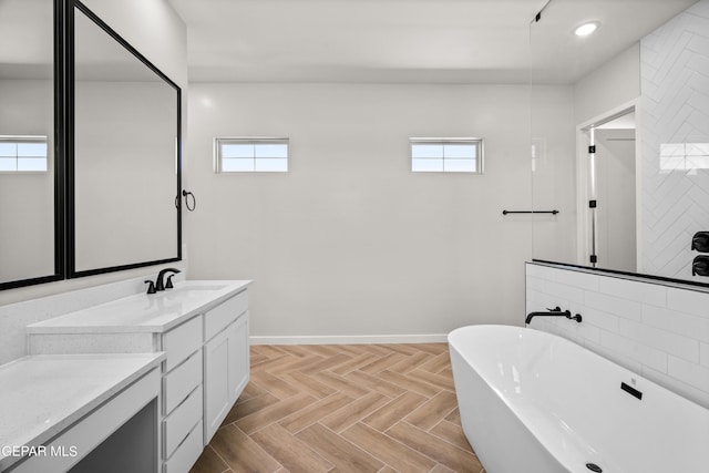 full bath with a freestanding tub, recessed lighting, baseboards, and vanity