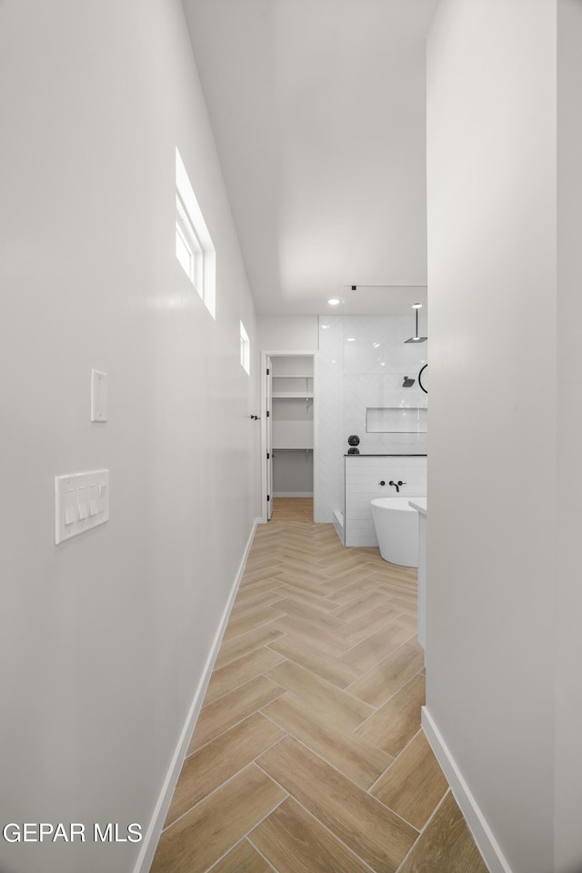 interior space featuring a freestanding bath, walk in shower, and baseboards