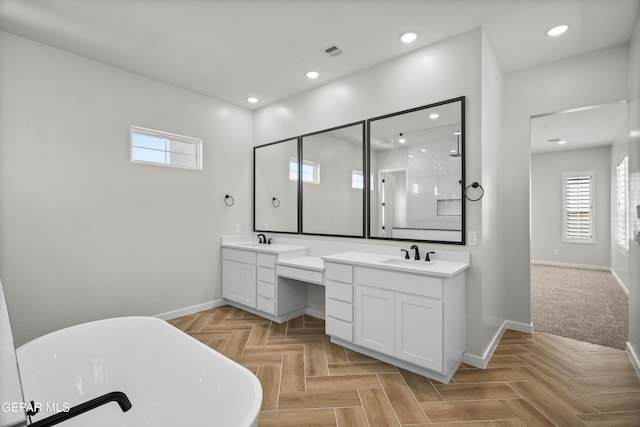 full bath with baseboards, visible vents, a soaking tub, vanity, and recessed lighting