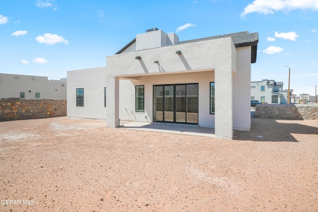 back of property with a patio and stucco siding