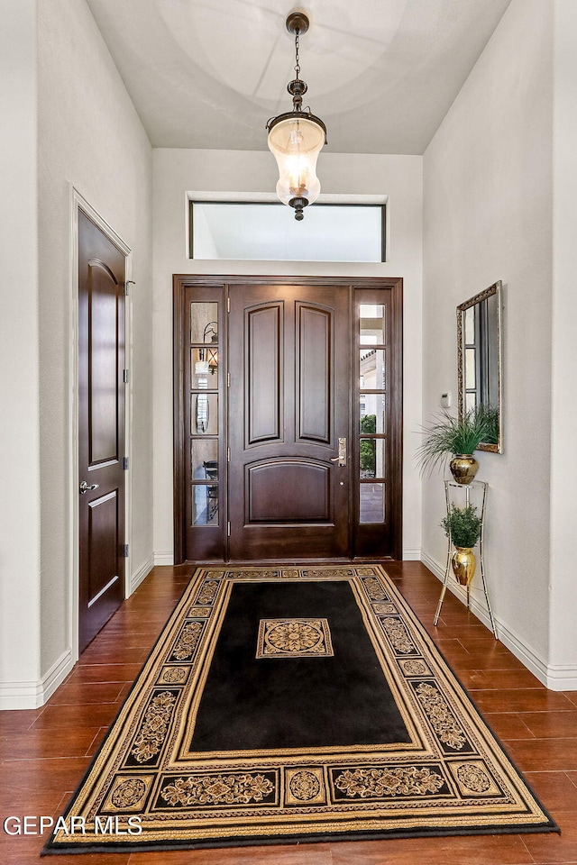 foyer with a notable chandelier and dark hardwood / wood-style floors