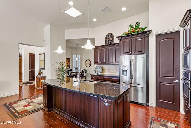 kitchen with a kitchen island with sink, appliances with stainless steel finishes, dark hardwood / wood-style floors, and sink