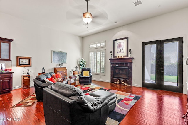 living room featuring ceiling fan, a fireplace, and hardwood / wood-style floors