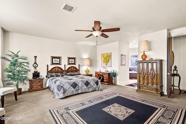 bedroom with ceiling fan, ensuite bathroom, and carpet flooring