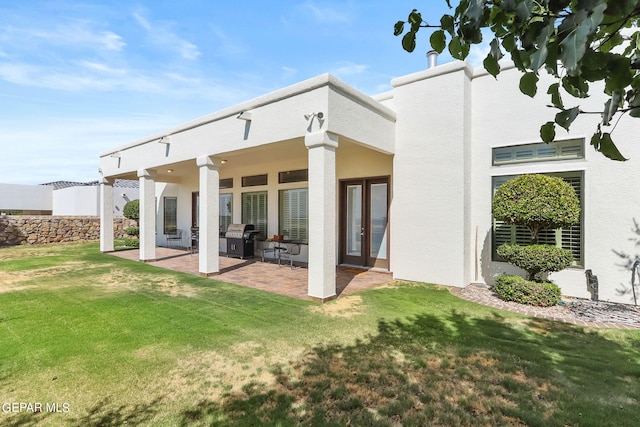 rear view of property featuring a yard and a patio area