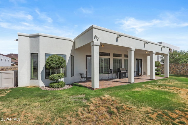 back of house with a lawn and a patio area