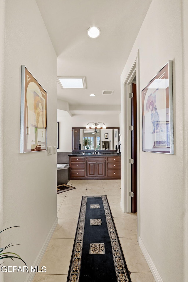 hallway featuring sink and light tile patterned floors