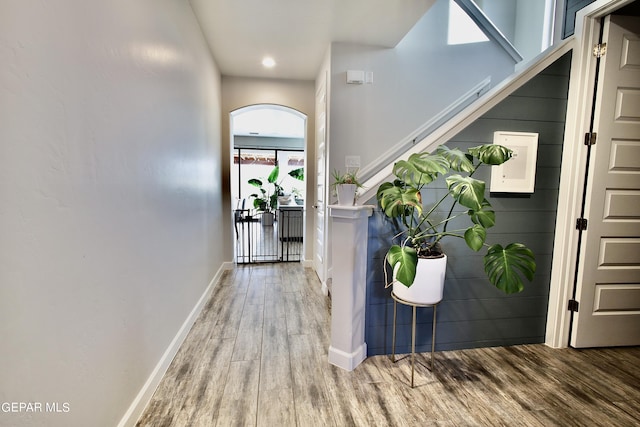 foyer entrance featuring baseboards, wood finished floors, and stairway
